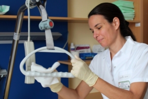 Frau putzt mit Desinfektionsmittel Krankenhausbett
